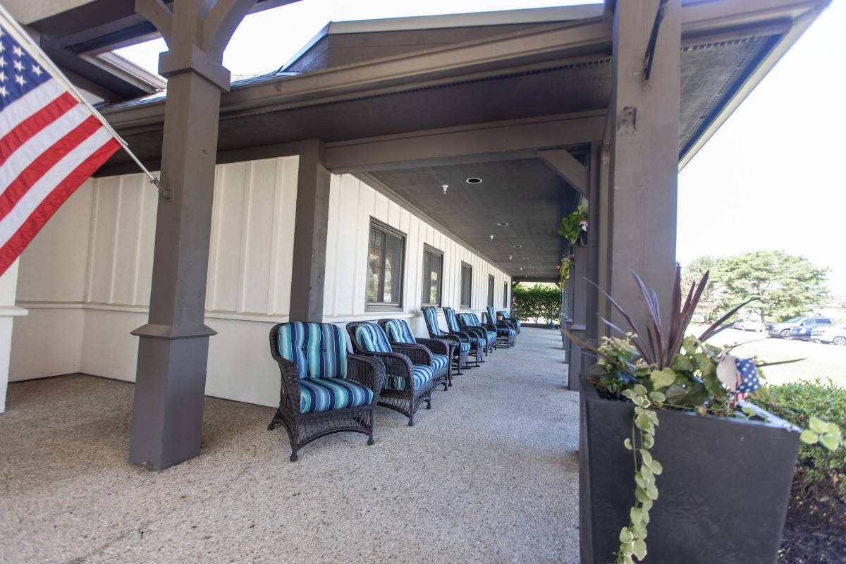 A row of striped chairs on an outdoor patio with a white building exterior.