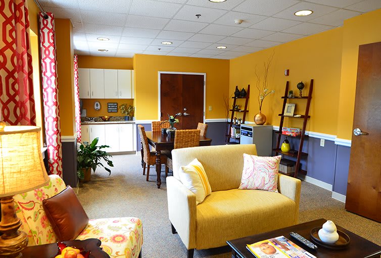 A cozy living room with yellow walls, comfortable seating, and decorative elements.