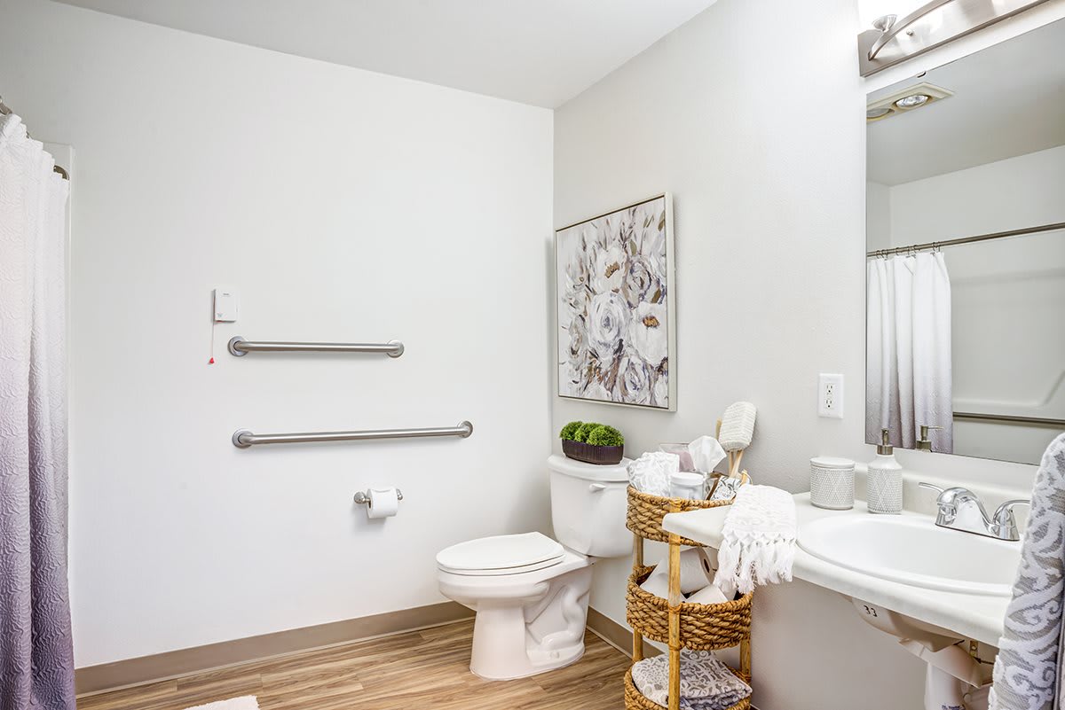 A clean and minimalist bathroom with a toilet, sink, and decorative elements.