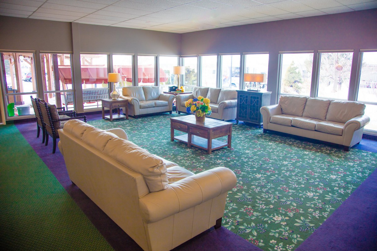 A bright lobby with comfortable sofas and a floral carpet.