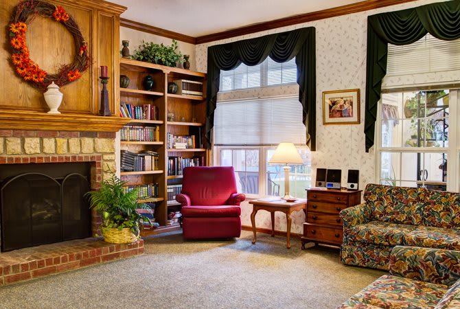Cozy living room with a fireplace, bookshelves, and comfortable seating.