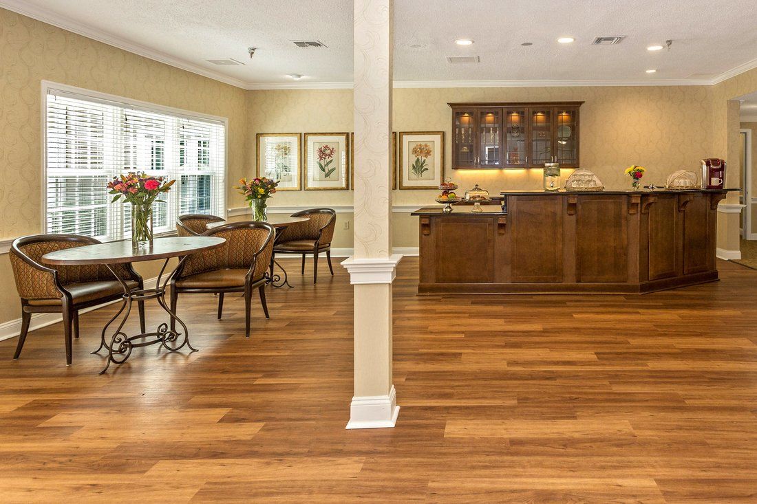 Spacious living room with a hardwood floor, featuring a dining area and a bar counter.
