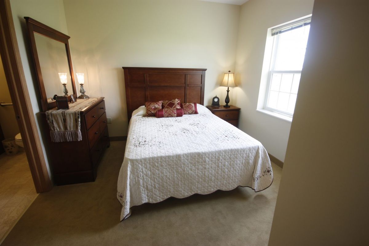 Cozy bedroom with wooden furniture and a large window.