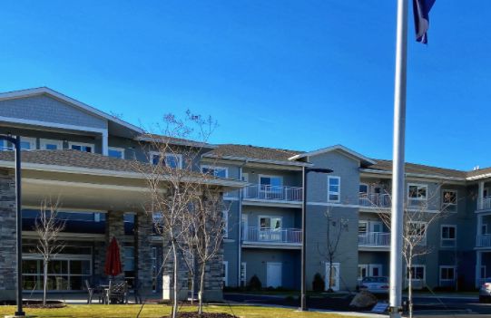 A modern residential apartment building under a clear blue sky.