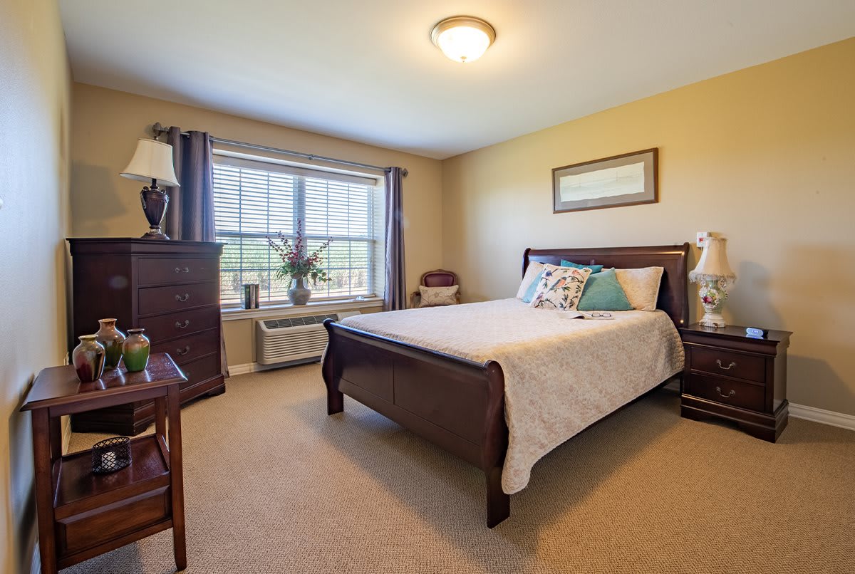 A cozy bedroom with stylish furnishings and a large window.