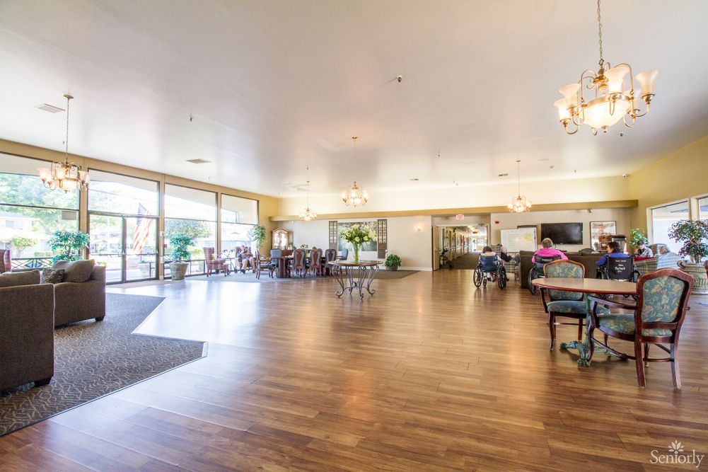A spacious and bright lobby with hardwood floors and furniture.