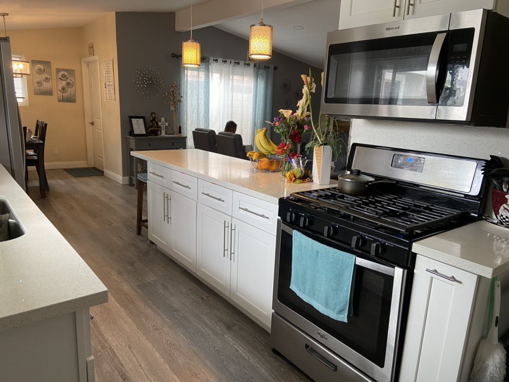 A modern kitchen interior with stainless steel appliances and white cabinetry.