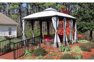 A charming gazebo set in a garden with autumn foliage and outdoor furniture.