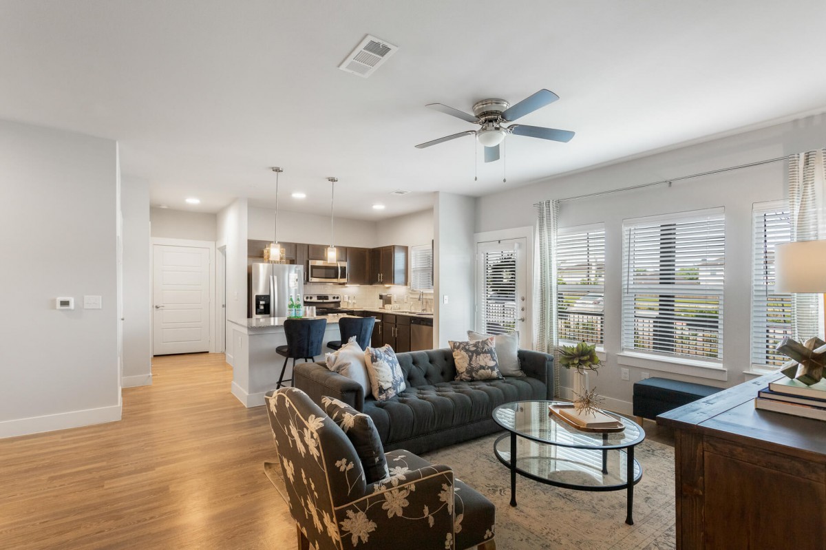 A modern open floor plan connecting a stylish living room and kitchen with neutral colors and contemporary furnishings.