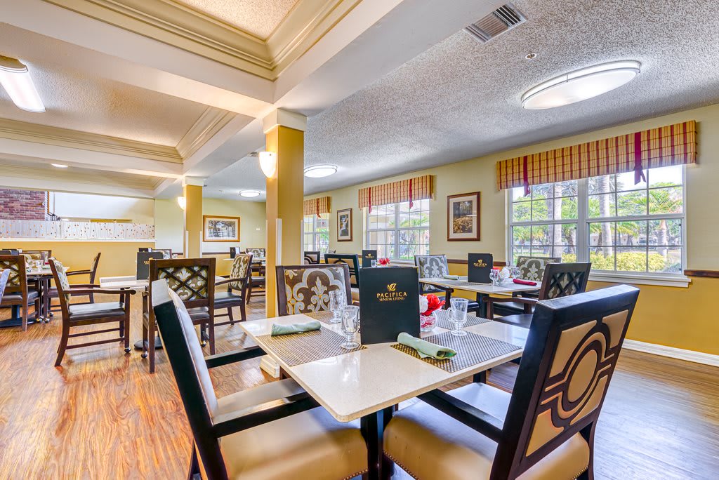 An inviting restaurant interior with neatly arranged tables and chairs, featuring menus placed on the tables.