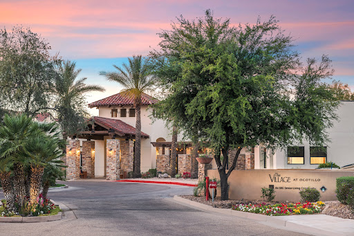 A beautiful entrance to a modern architectural residence surrounded by palm trees during sunset.