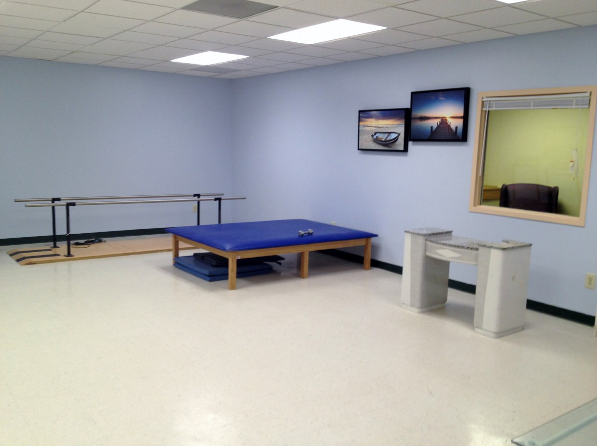 A physical therapy room with exercise equipment and minimalist design.