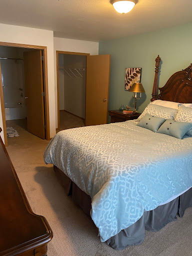 A cozy bedroom featuring a neatly made bed, warm colors, and inviting decor.