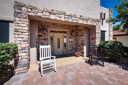 A charming entrance featuring rocking chairs and a stone facade.