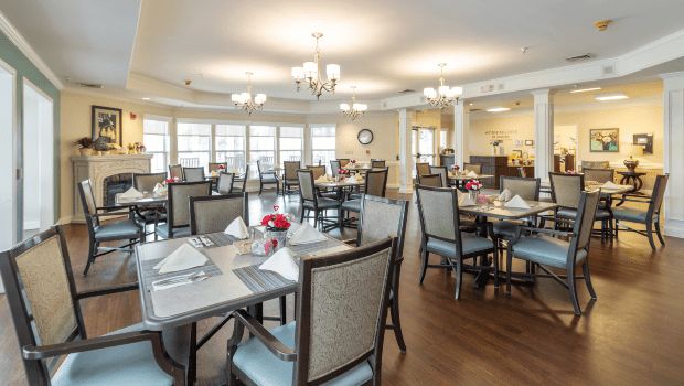 An elegant dining room setup with neatly arranged tables and chairs, featuring soft lighting and tasteful decor.