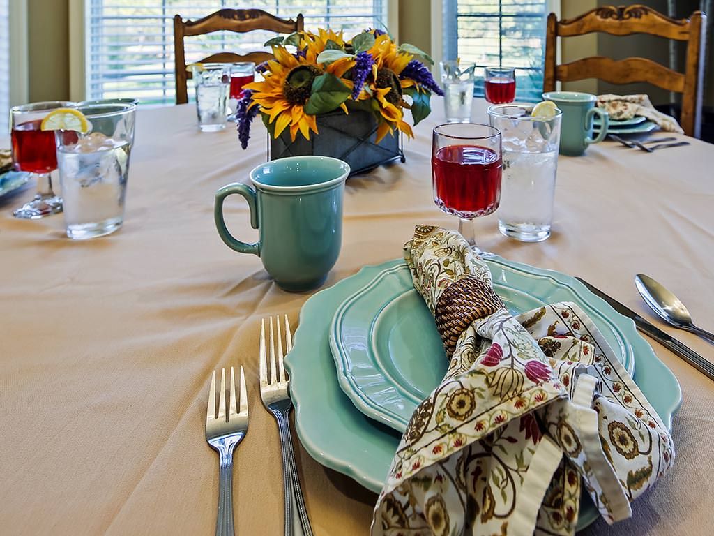 A beautifully arranged dining table with elegant tableware and a vibrant floral centerpiece.