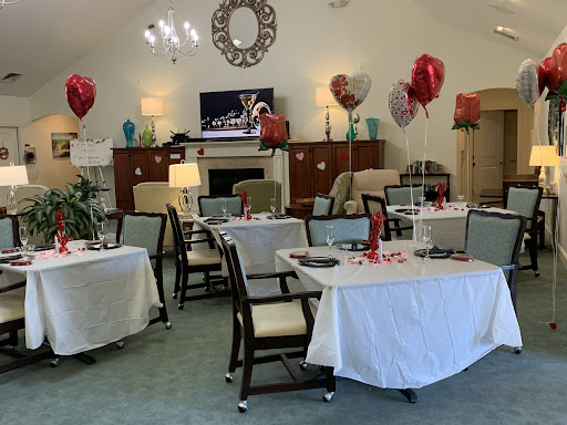 A beautifully decorated dining area ready for a Valentine's Day celebration, featuring tables set with white tablecloths and heart-shaped balloons.