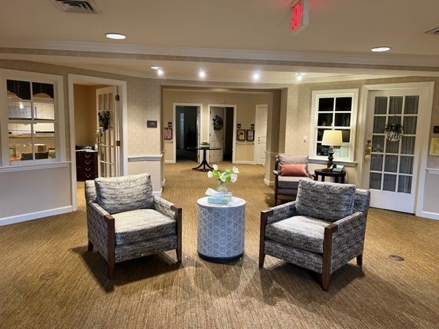 A cozy lobby area featuring two armchairs and a small round table, with ambient lighting and decorative elements.