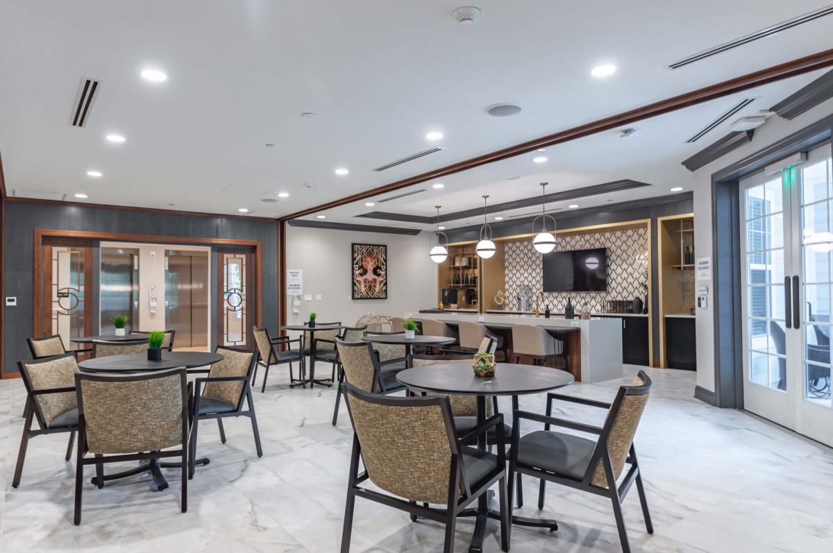 A modern dining area with round tables and chairs, featuring stylish lighting and decor.