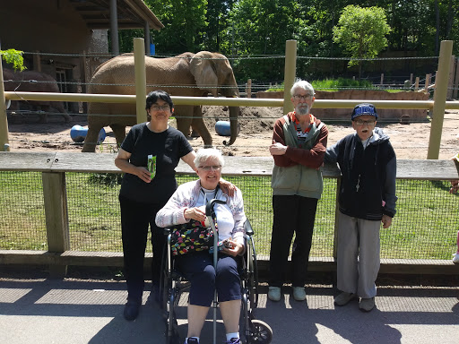 A family visit to the zoo with an elephant in the background.