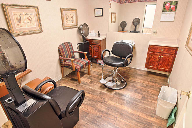A cozy hair salon interior with styling chairs and various equipment.