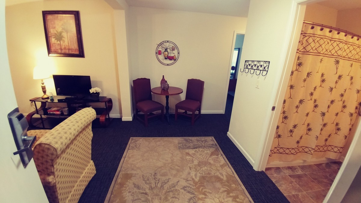 A cozy living room corner with a small table and chairs, decorated with a wall piece.