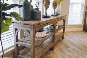 A rustic wooden console table adorned with decorative vases and plants.