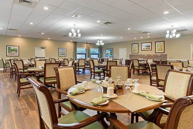 An elegant dining room with neatly arranged tables and chairs, featuring modern lighting and decor.