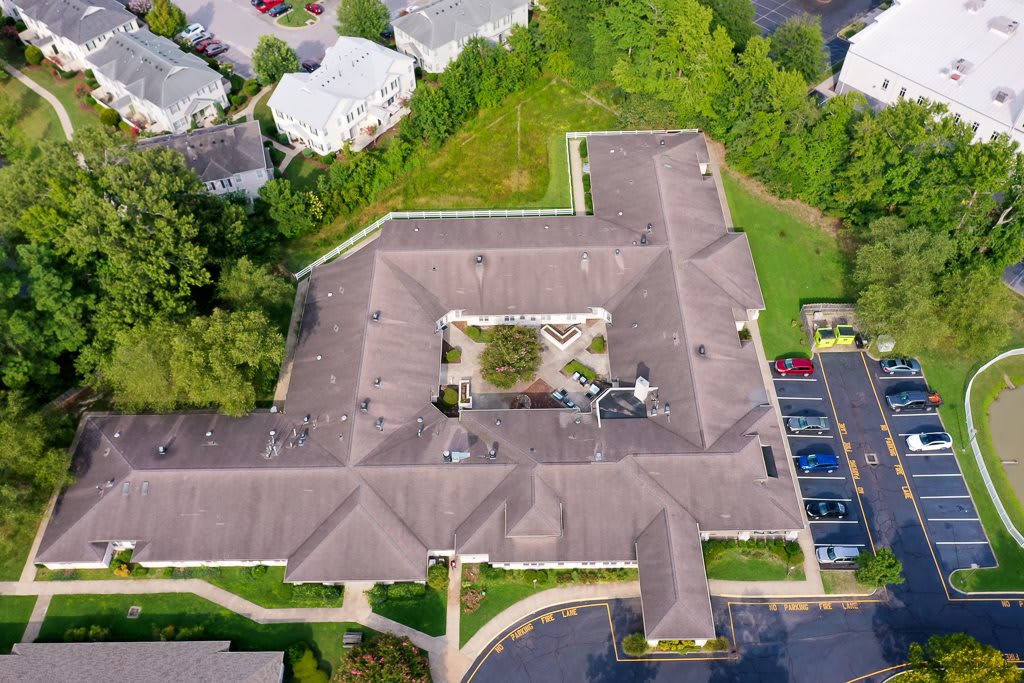 Aerial view of a residential building with a central courtyard and surrounding greenery.