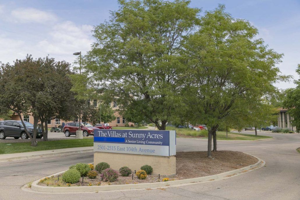 Entrance sign for a hospital surrounded by trees and landscaping.