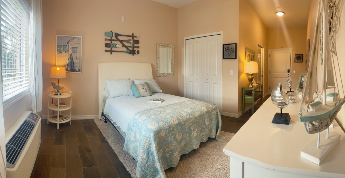 A cozy bedroom with soft lighting and a neatly arranged bed.