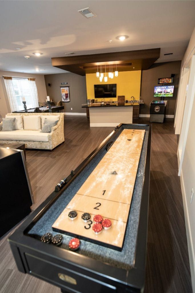 A cozy game room featuring a shuffleboard table and modern amenities.