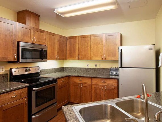 A modern kitchen featuring stainless steel appliances and wooden cabinets.