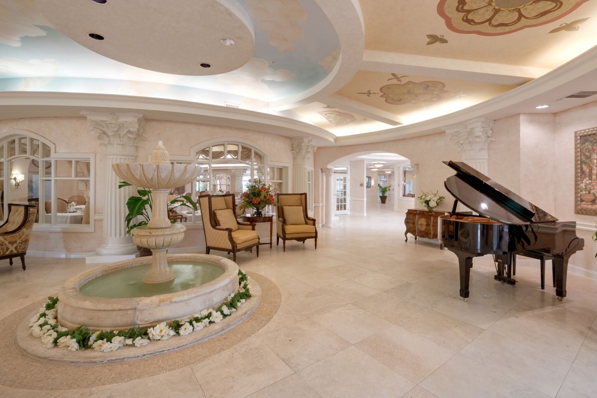 Luxurious interior with elegant decor, featuring a grand piano and indoor fountain.
