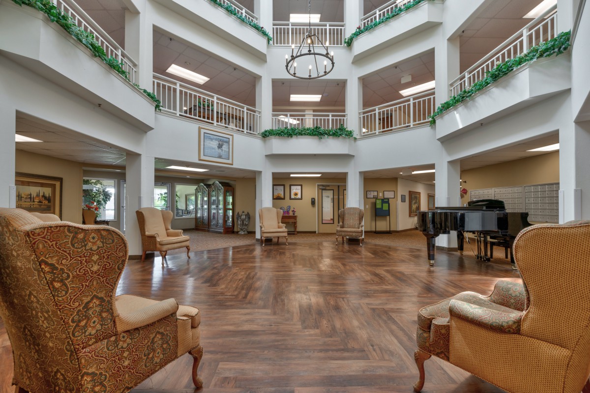 A spacious atrium lobby with elegant furniture and a grand piano.