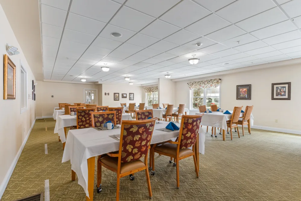 A spacious dining area with neatly arranged tables and chairs in a well-lit setting.