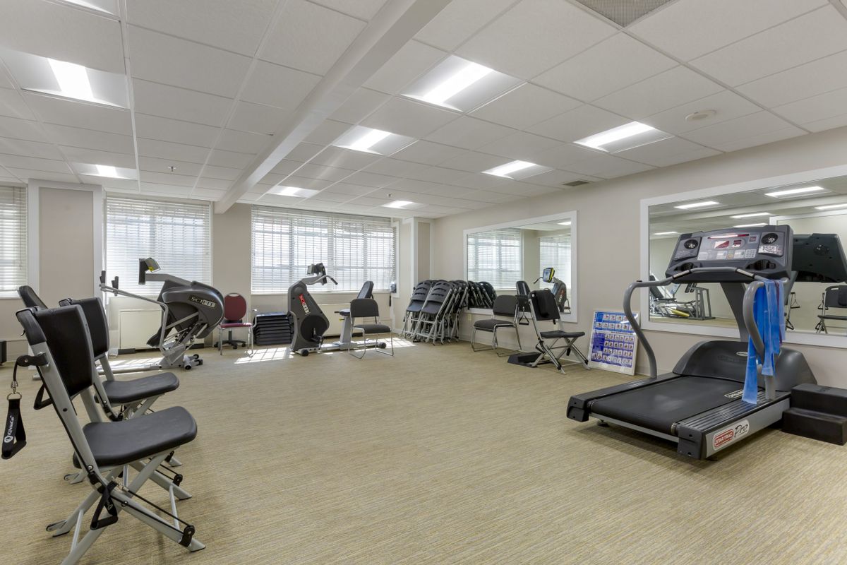 A spacious fitness room equipped with various exercise machines and treadmills.