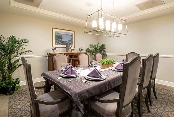 An elegantly set dining room table, complete with a chandelier and tasteful decor.