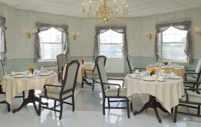 An elegant dining room with beautifully set tables and a chandelier.