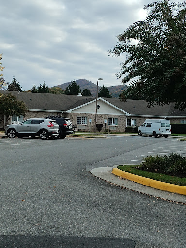 A peaceful residential area with a parking lot and overcast skies.