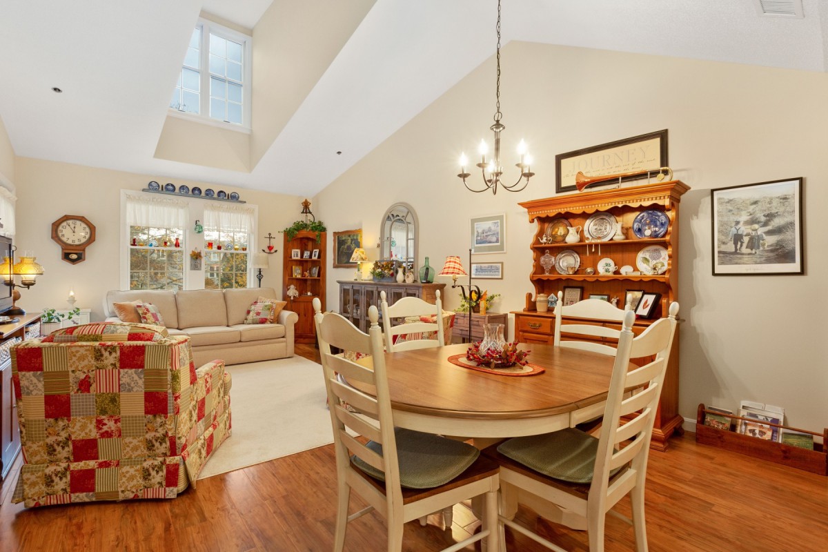 A cozy dining and living area featuring a wooden table and chairs, a comfortable sofa, and elegant interior decor.