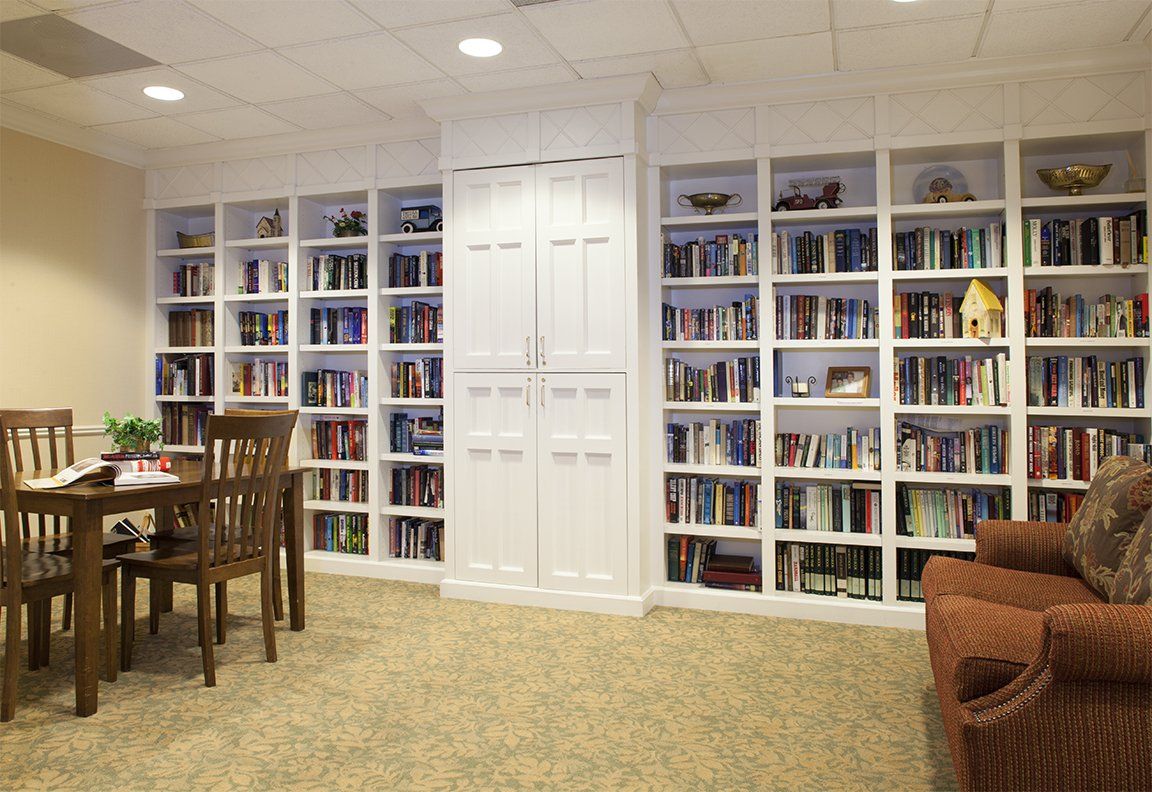 A cozy home library featuring a wall of bookshelves filled with various books.