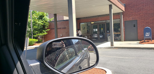 A view from a car's side mirror showing the entrance of a building.