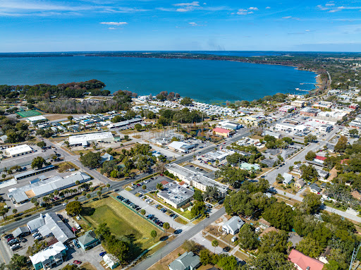A scenic aerial view of a coastal town nestled by the water, showcasing a blend of natural beauty and urban development.