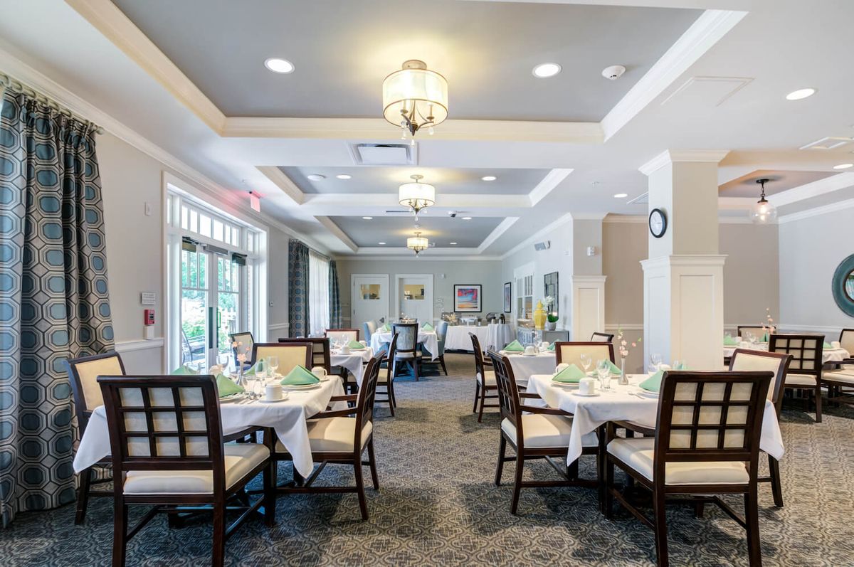 An elegant dining room with neatly set tables and stylish lighting.