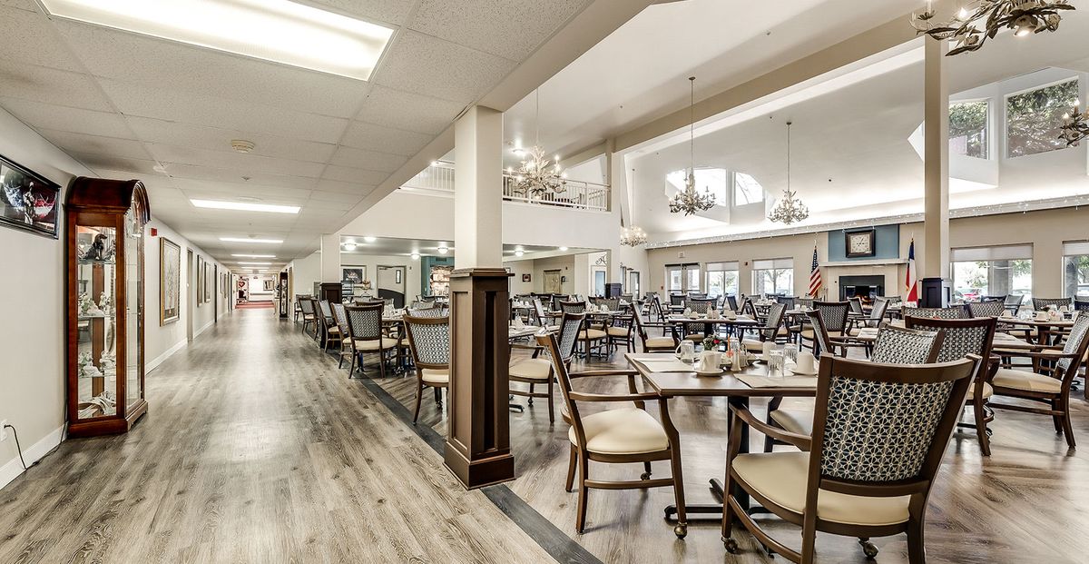 Spacious and elegantly designed dining area with chandeliers and neatly arranged tables.