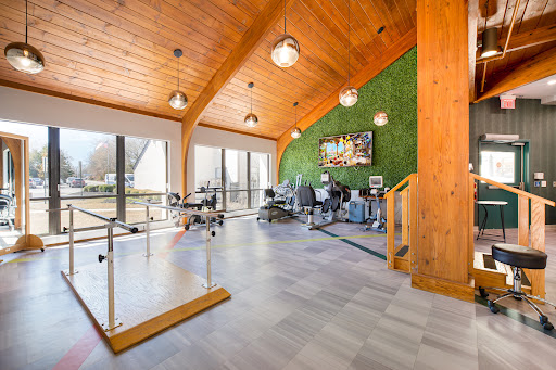 A contemporary office space featuring a green wall and wooden beams, designed for an inviting work environment.
