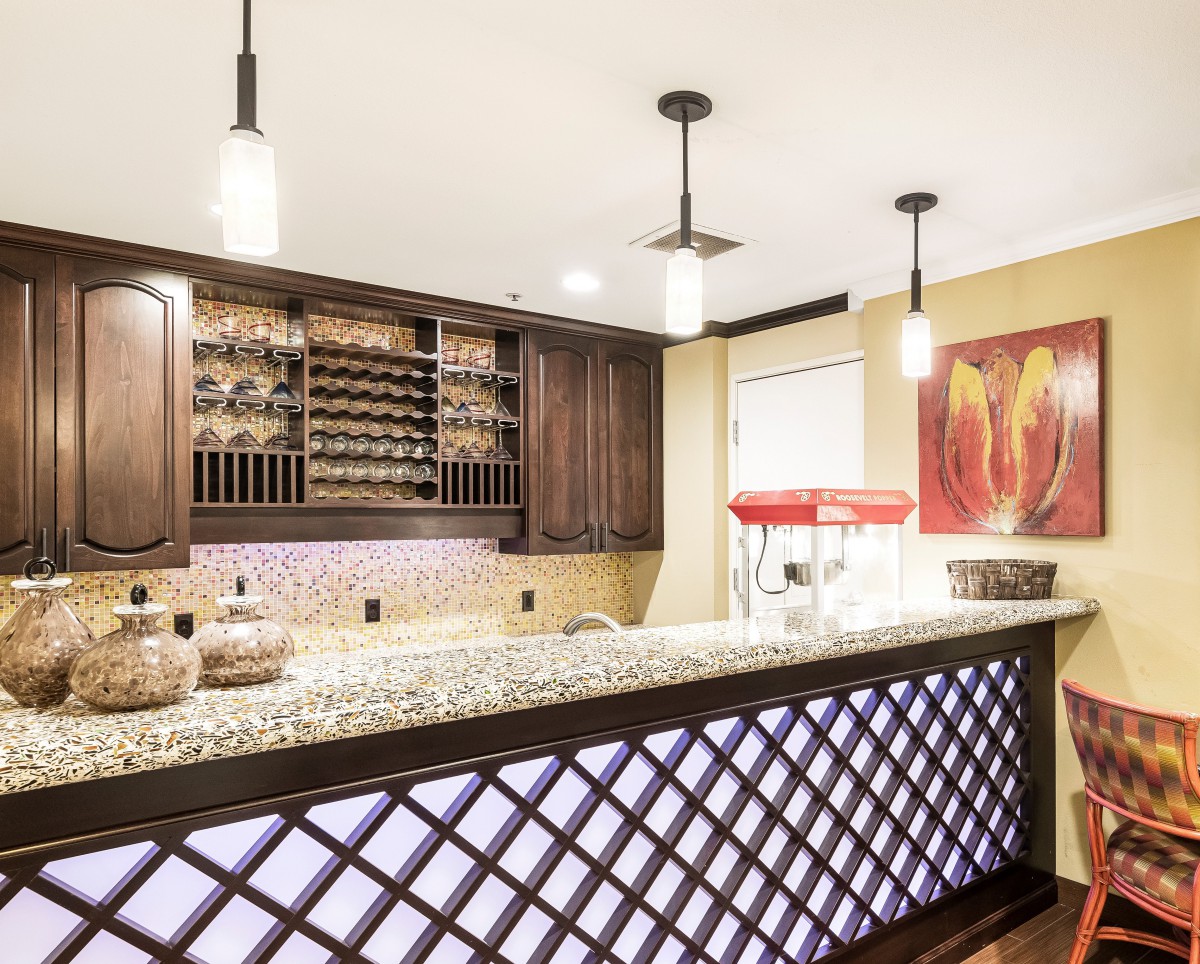 A stylish home bar with modern lighting and a wine rack.