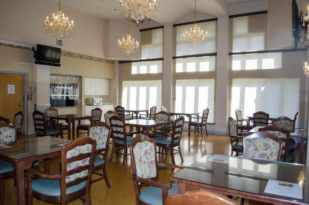 A bright dining area with elegant chandeliers and large windows.