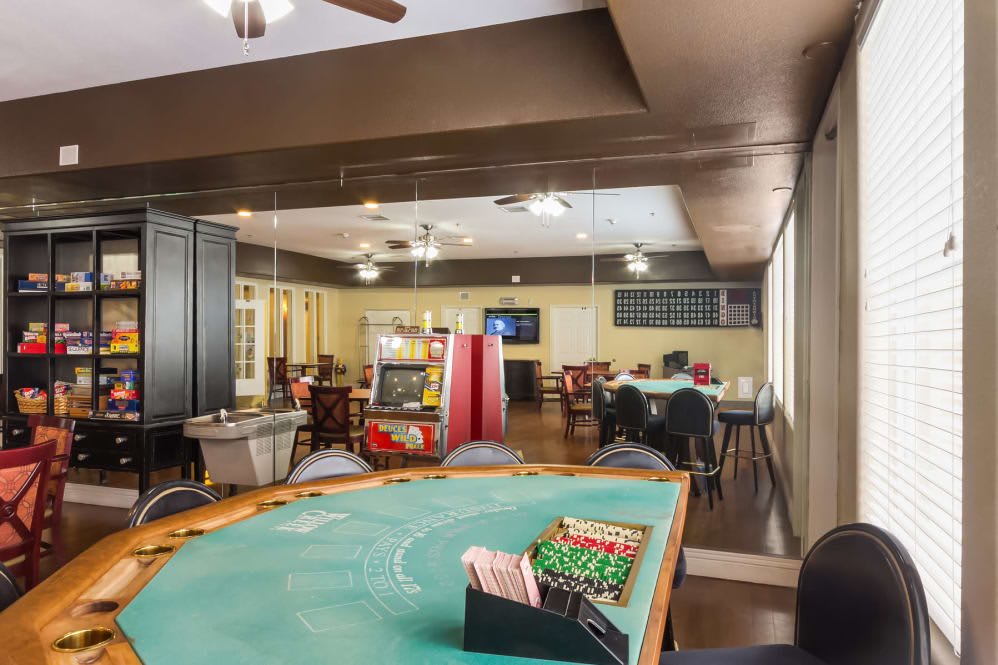 A vibrant gaming room featuring card tables and an arcade machine.